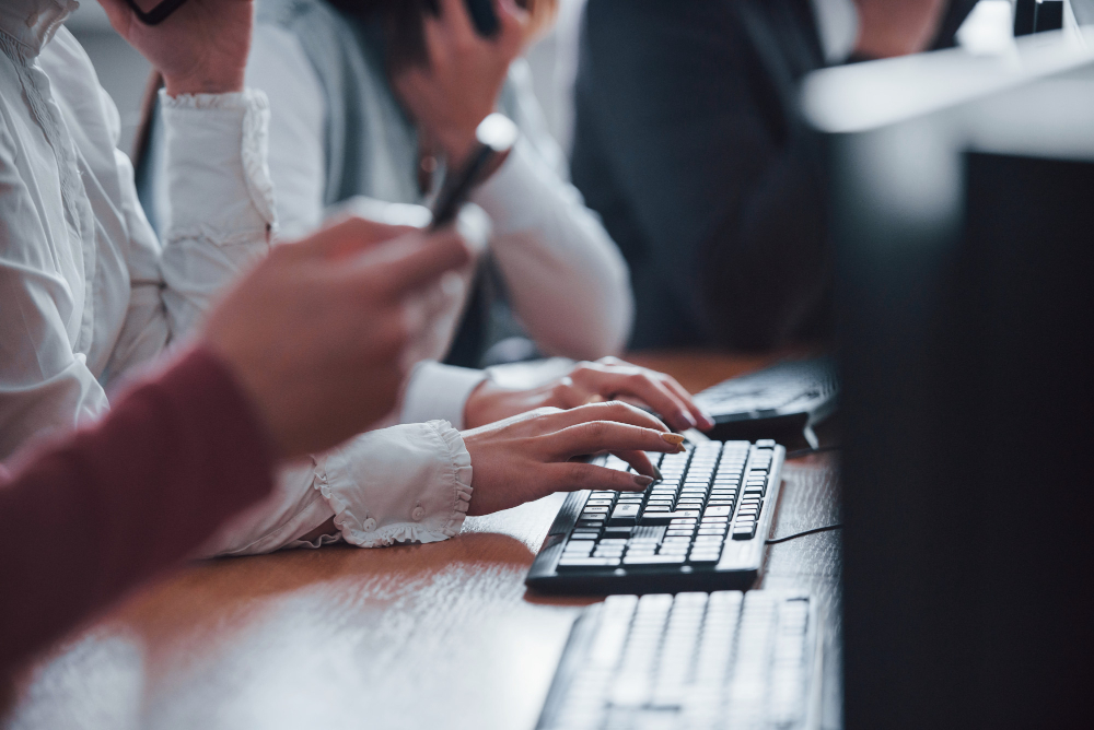 close up view of woman s hands typing on keyboard young people working in the call center new deals is coming site