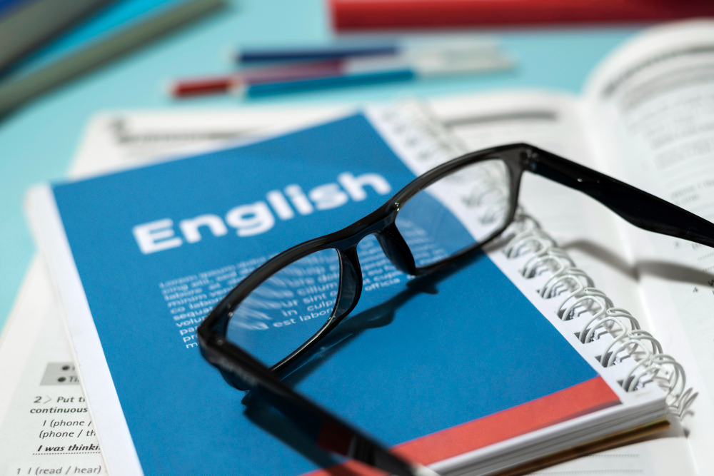 livro de ingles com oculos na mesa